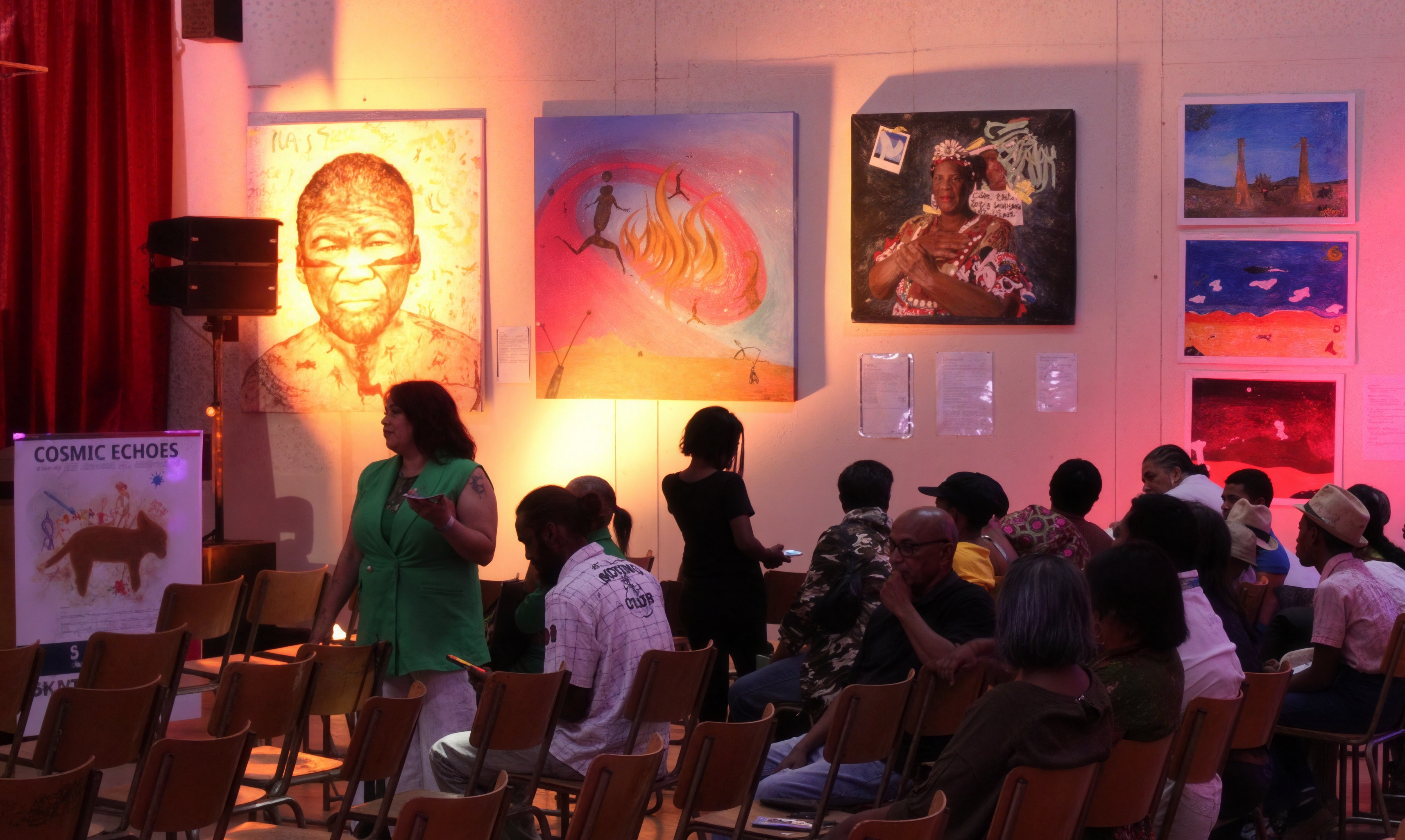 People at the opening of Cosmic Echoes in Carnarvon, with artworks on display on the walls.