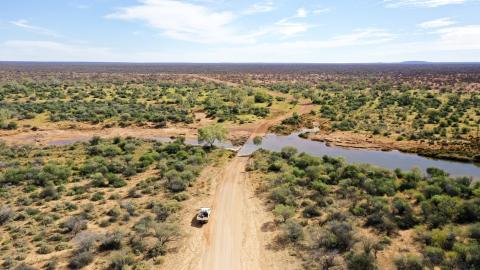 An aerial view of the Australian outback near the SKA site. The land is flat to the horizon with low vegetation.