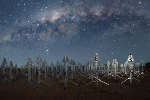The Milky Way above SKA-Low antennas that look like metal Christmas trees.