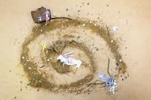 Composition of different elements: a spiral of sand surrounded by stars and people. 