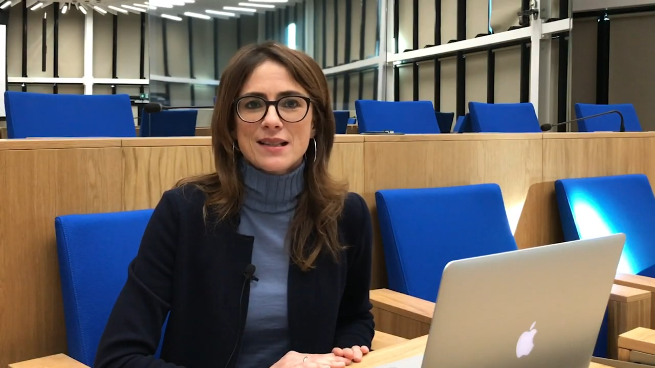 Dr Chiara Ferrari sitting in the SKAO Council Chamber with a laptop in front of her