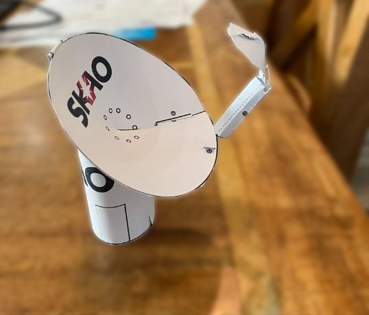 Picture of a paper model SKA-Mid dish on a wooden table.