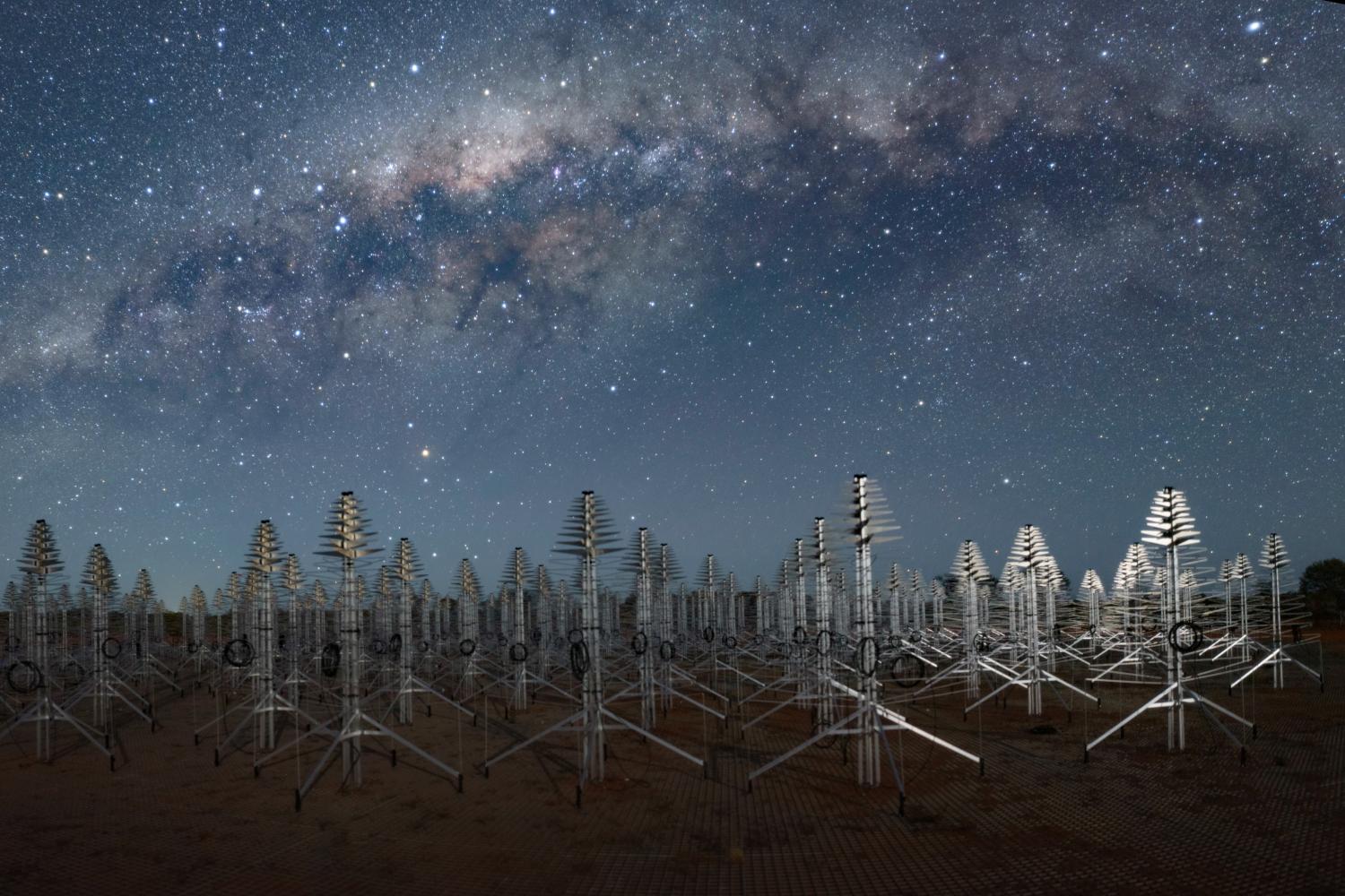 The Milky Way above SKA-Low antennas that look like metal Christmas trees.