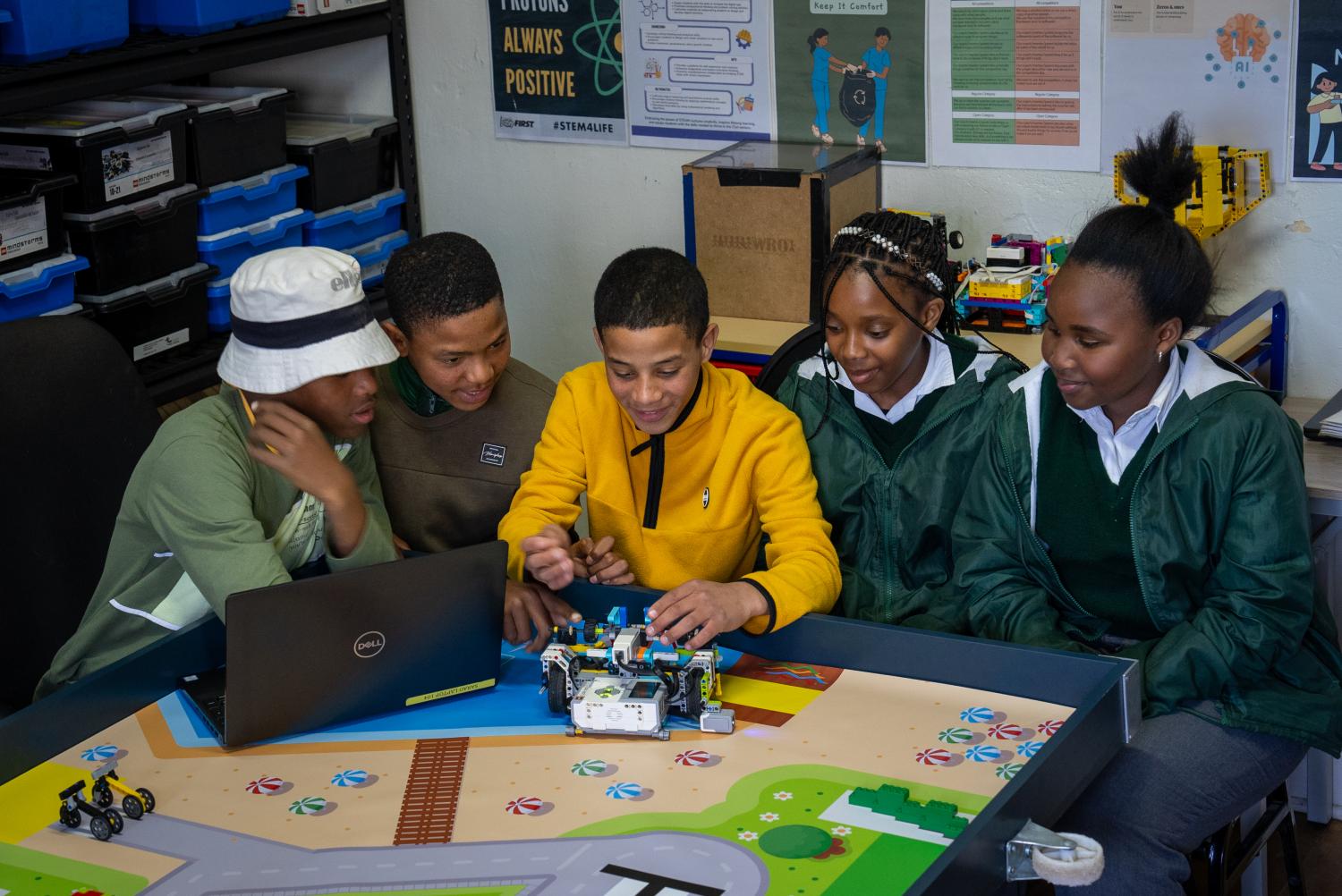 A group of three students looking at a Lego robot