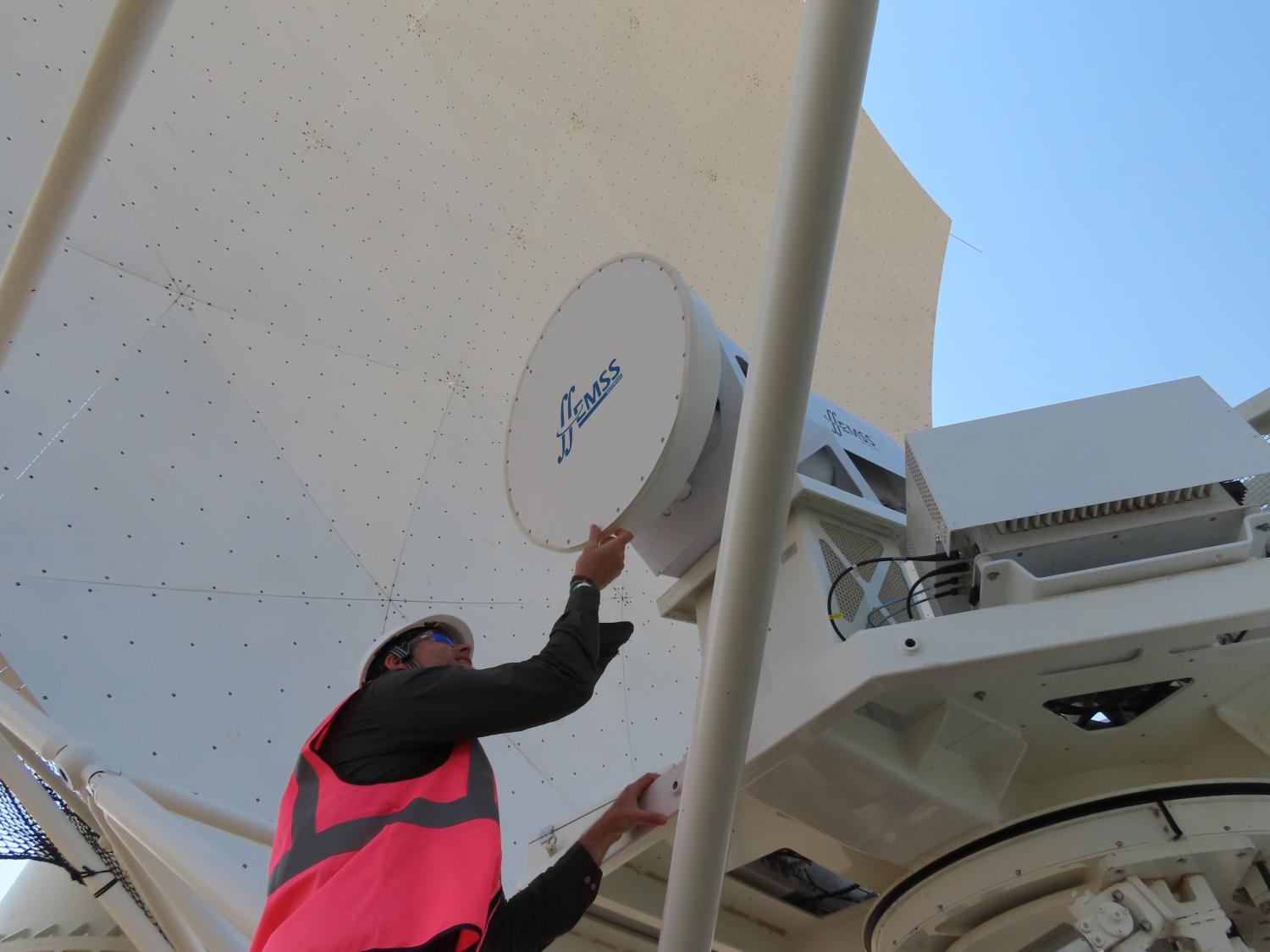 Picture of someone wearing a high-vis jacket working on a telescope receiver.